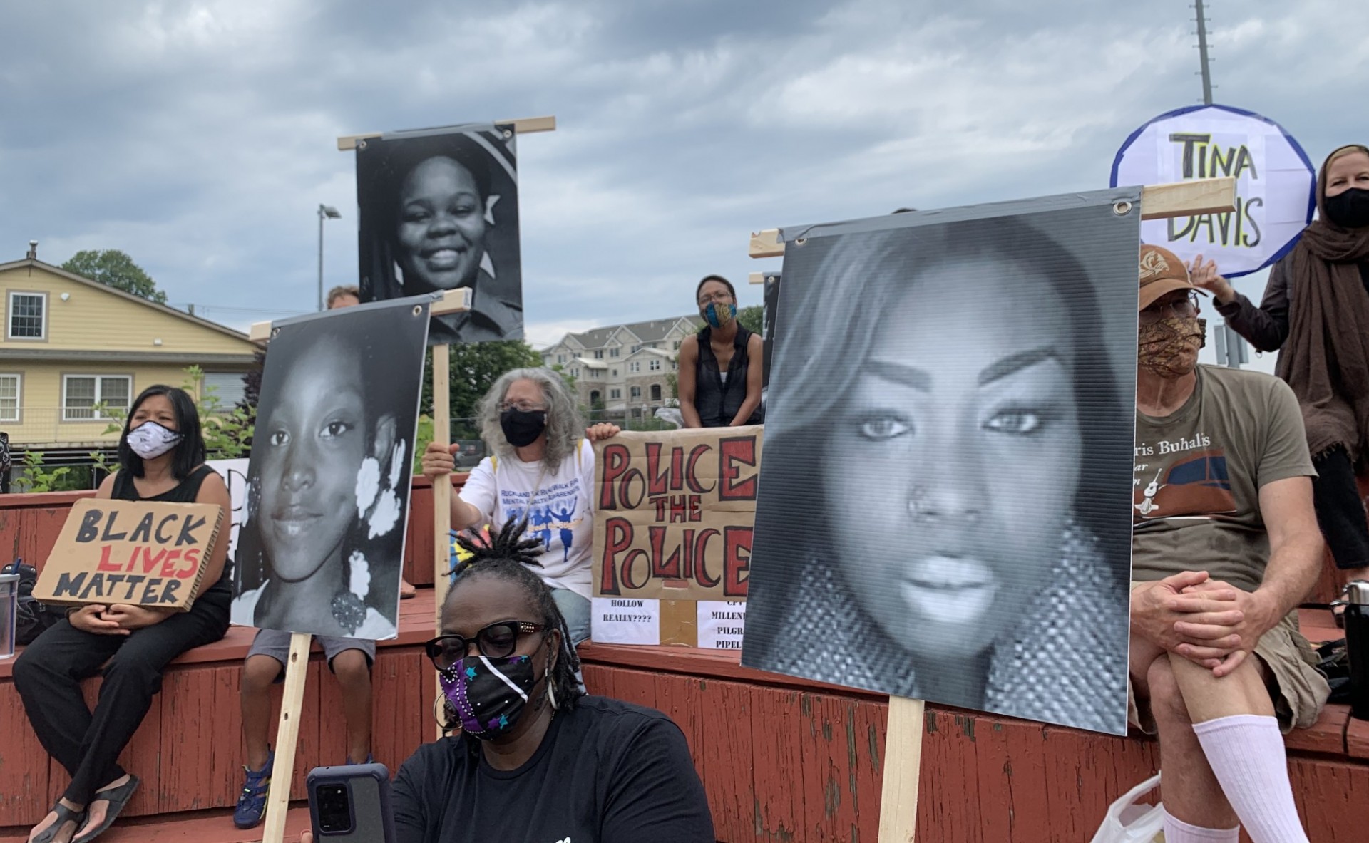 Rally in Rockland County with participants holding photos of women who have been killed by police